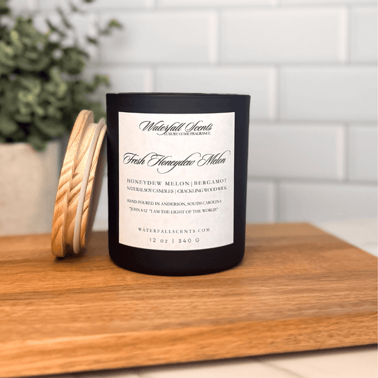 Fresh Honeydew Melon wooden wick candle in a sleek black glass jar with white label. Hand poured, clean burning, and made with the best natural candle ingredients.