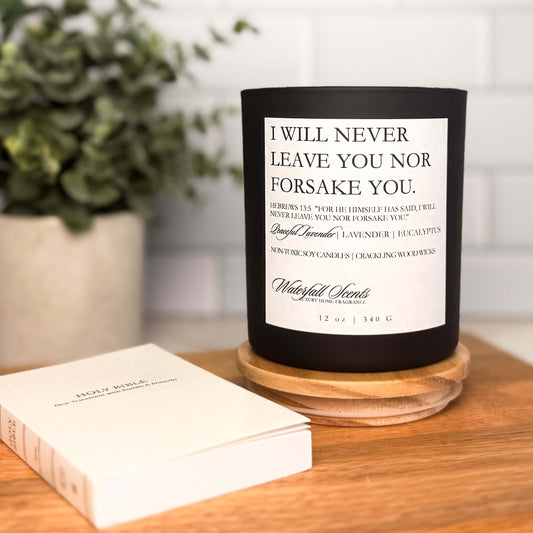 Black glass jar scripture candle with wooden wick and white label that reads “I Will Never Leave You Nor Forsake You.” Hand poured, clean burning.