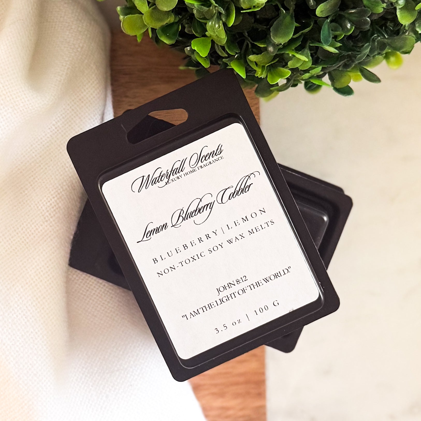 Lemon Blueberry Cobbler wax melts in a sleek black clamshell. Hand poured and clean burning with notes of lemon zest, sweet blueberries, and baked sugar.