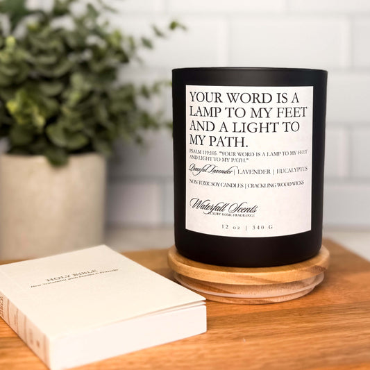 Black glass jar candle with white label reading “Your Word is a Lamp to My Feet.” Wooden wick, hand poured soy wax, clean burning and non-toxic.