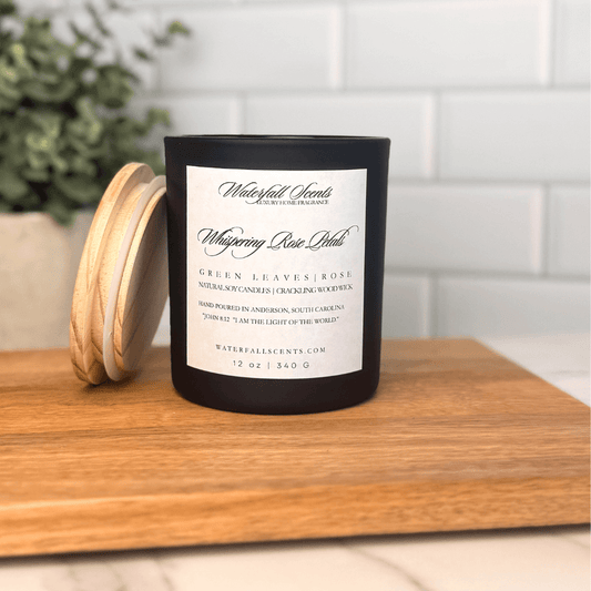 Whispering Rose Petals wooden wick candle in a black glass jar with a white label. Hand poured with non-toxic ingredients for a soft floral scent.