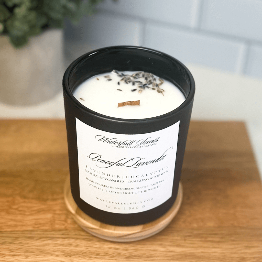 Peaceful Lavender candle in a sleek black jar with a white label – hand poured Christian candle, wooden wick, clean burning, and made with 100% soy wax and dried lavender.