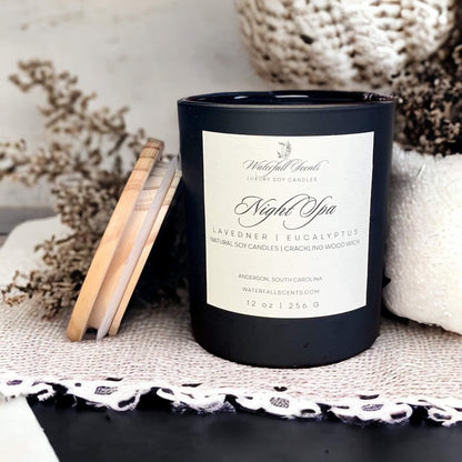 imagine a cozy living room with a lit Night Spa Wooden Wick Candle, creating a soothing ambiance with soft music playing in the background. Perfect for busy women in need of relaxation. comes in black glass vessel